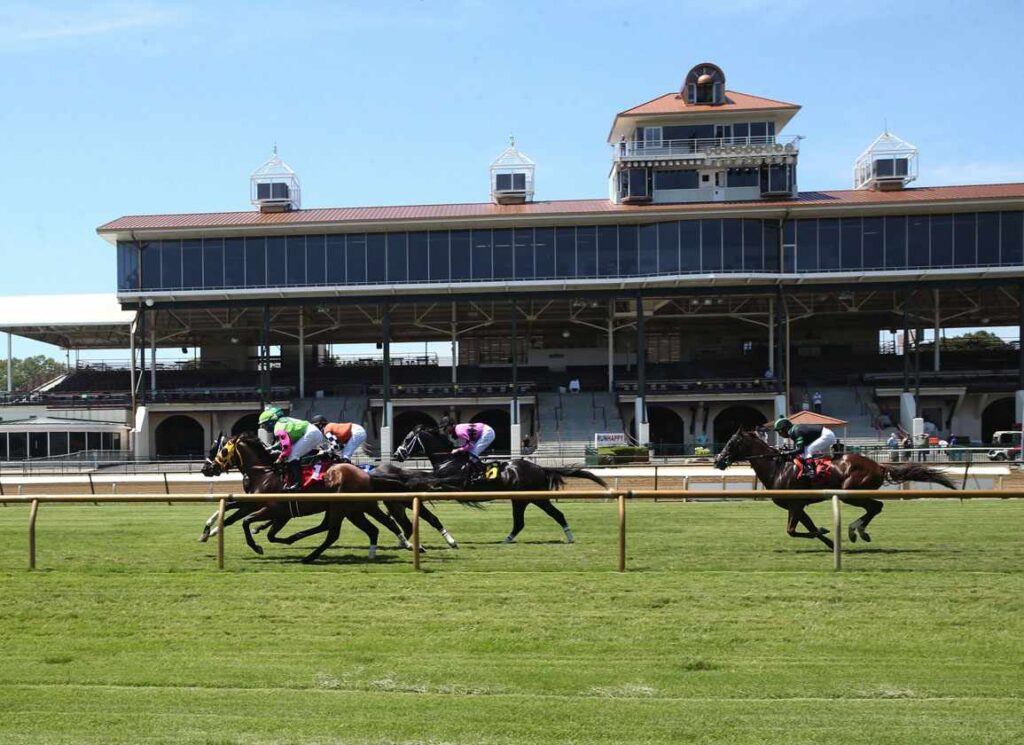 Horses racing at Ellis Park with the grandstand in the background