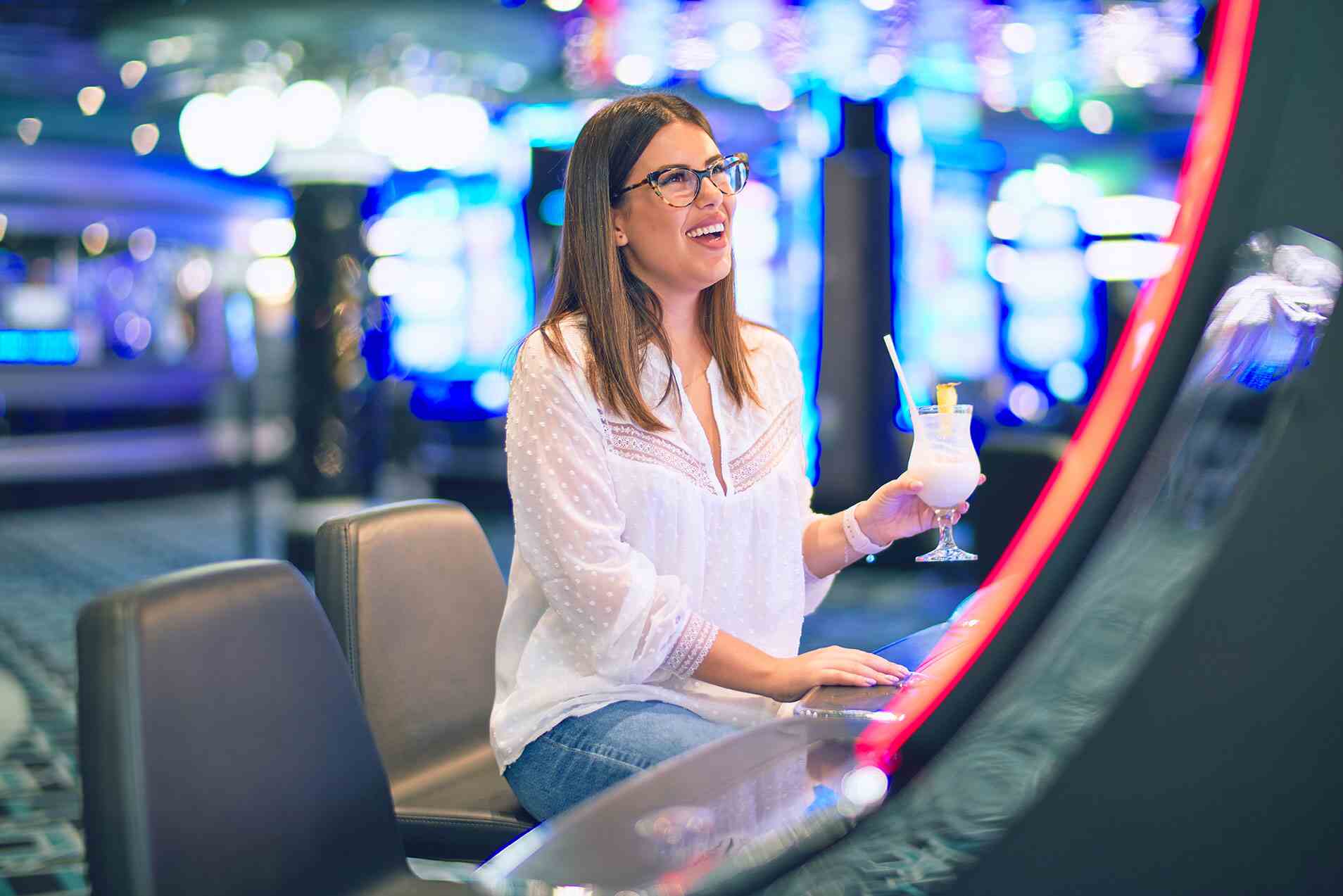 Woman gaming on a machine drinking a drink